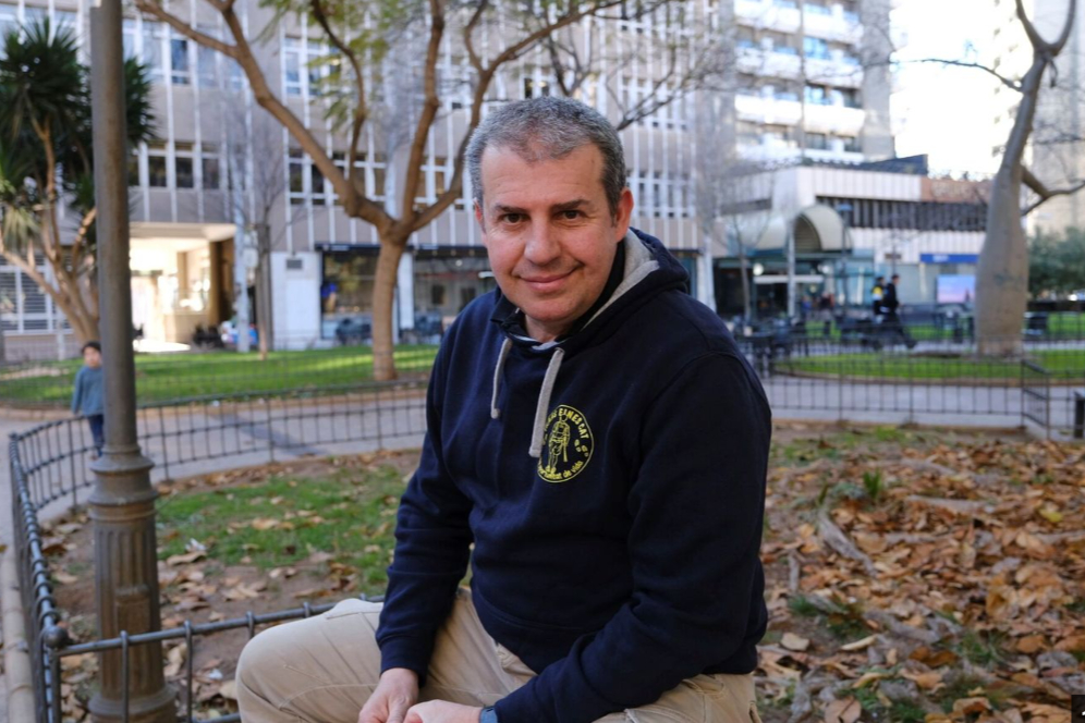 Àlex Florensa assegut en una plaça, somrient